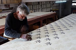 artisan indien en plein travail du tissu